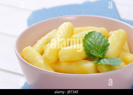 Schale von gekochten Kartoffel Kegel oder Gnocchi auf blauen Tischset - Nahaufnahme Stockfoto