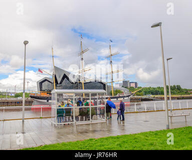 Glasgow, Schottland. 3. August 2017. Großbritannien Wetter. Passagiere warten an den Ufern des Flusses Clyde für die Govan Fähre zu nehmen sie über das Riverside Museum und Großsegler, lebhafteste, an einem sonnigen Tag mit teils sonnig und häufige schwere Duschen Credit: Skully/Alamy Live News Stockfoto