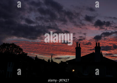 London, UK. 4. August 2017. Wohn Dächern in Wimbledon sind Silhouette gegen einen atemberaubenden Sonnenuntergang Sommer Credit: Amer Ghazzal/Alamy Live-Nachrichten Stockfoto