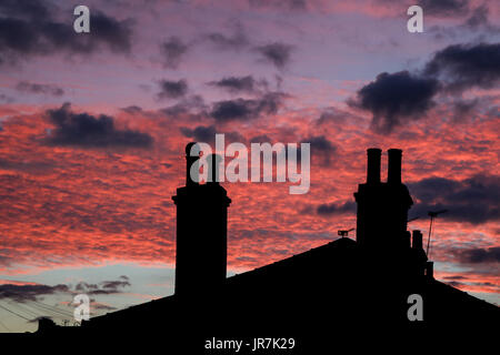 London, UK. 4. August 2017. Wohn Dächern in Wimbledon sind Silhouette gegen einen atemberaubenden Sonnenuntergang Sommer Credit: Amer Ghazzal/Alamy Live-Nachrichten Stockfoto