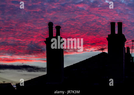 London, UK. 4. August 2017. Wohn Dächern in Wimbledon sind Silhouette gegen einen atemberaubenden Sonnenuntergang Sommer Credit: Amer Ghazzal/Alamy Live-Nachrichten Stockfoto