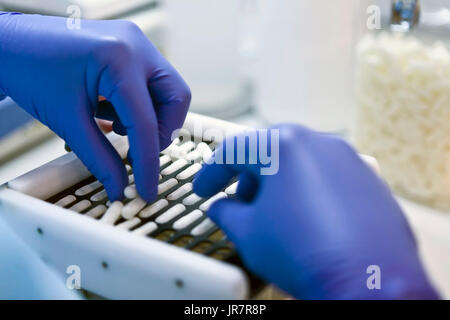 Verpacken weiße Kapseln in einer Sortiermaschine in einem pharmazeutischen Labor, Spanien Stockfoto