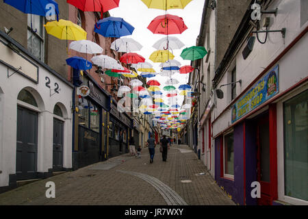 Menschen zu Fuß durch die Straße in Enniscorthy, Irland mit schwebenden Sonnenschirme für den Rockin' Food Festival eingerichtet Stockfoto