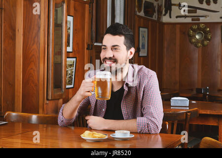 Porträt des Jünglings Latein, trinken Bier und Snacks an der Bar zu essen. Im Innenbereich. Stockfoto