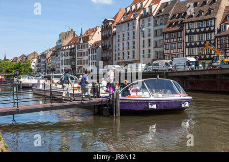 Touristen, die ein Batorama Sightseeing Boot / Bateau-Promenade am Fluss Ill in Straßburg, Elsass, Zentralfrankreich. Einige typische Architektur der Stockfoto