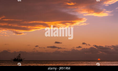 Sonnenuntergang über der Bucht mit einem Fischerboot am Horizont Stockfoto