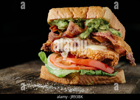 Huhn und Avocado BLT Sandwich auf schwarzem Hintergrund Stockfoto