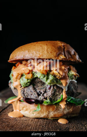 Saftige Veggie-schwarze Bohnen-Burger auf dunklem Hintergrund Stockfoto