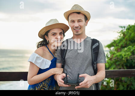 Lächelnde paar nehmen Selfie mit Drohne. Glückliches junges Paar im Urlaub Stockfoto