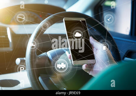 Man-Fahrer mit Smart self-driving Car Control System auf einer hand Telefon. Futuristische fahrt Technologie Konzept. Stockfoto