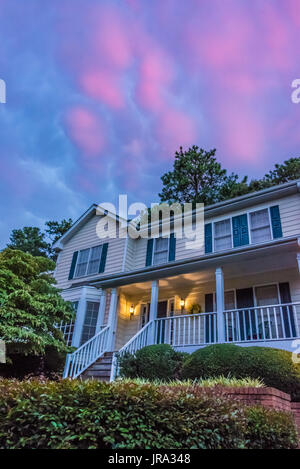 Farbenfrohe Sonnenuntergang Wolken malen den Himmel wie Abend über ein Haus in Metro Atlanta, Georgia fällt. (USA) Stockfoto
