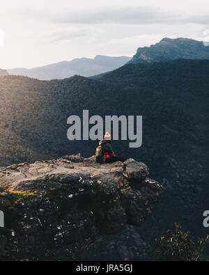 Touristen sitzen auf den Felsen mit einem wunderschönen Sonnenaufgang auf die Balkone in den Grampians National Park, Victoria, Australien. Stockfoto