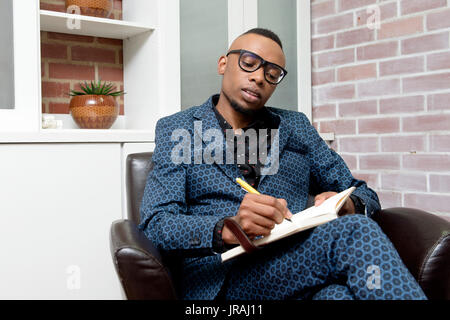 Young Business Mann schreiben in einen Notizblock Stockfoto