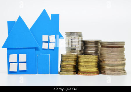 Blaues Papier Hausmodell und Stapel von Münzen Stockfoto