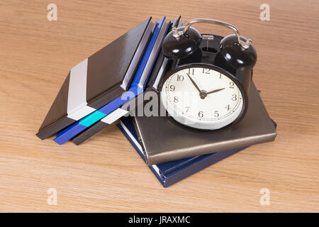 Hohe Betrachtungswinkel der Wecker zu Haufen von Notebooks Stockfoto