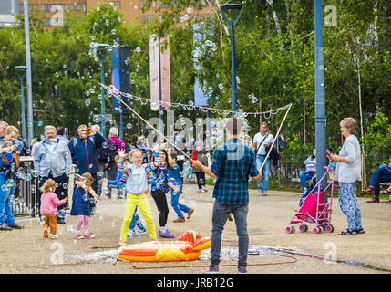 Straße Entertainer Hereinholen Tipps unterhalten Kinder durch Einblasen große bunte Luftblasen, Bankside, Böschung, South Bank, London SE1, UK Stockfoto