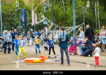 Straße Entertainer Hereinholen Tipps unterhalten Kinder durch Einblasen große bunte Luftblasen, Bankside, Böschung, South Bank, London SE1, UK Stockfoto