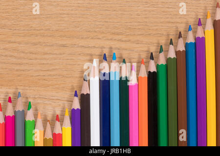 Dekorative Zick-zack-Anordnung der Buntstifte mit geschärften Punkte auf einer hölzernen Hintergrund mit Kopie Raum Stockfoto