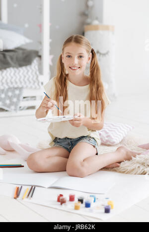 Lächelnde Mädchen holding Palette und lächelnd in die Kamera Stockfoto