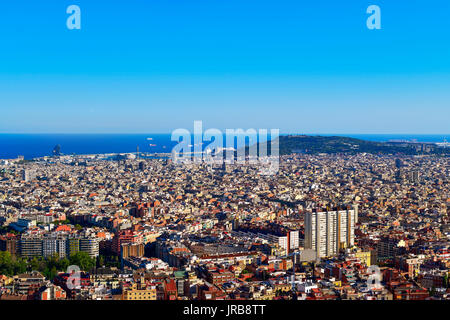 Ein Luftbild von Barcelona, Spanien, aus der Turo de la Rovira Hill gesehen, mit dem Montjuic Hügel die Hervorhebung nach rechts, und das Mittelmeer. Stockfoto
