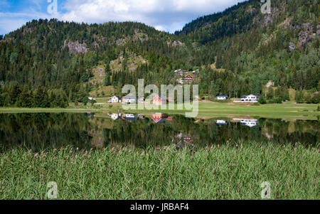 Häuser im Tal, die in das Wasser gebaut auf der Bank eines Fjord, Telemark, Norwegen Stockfoto