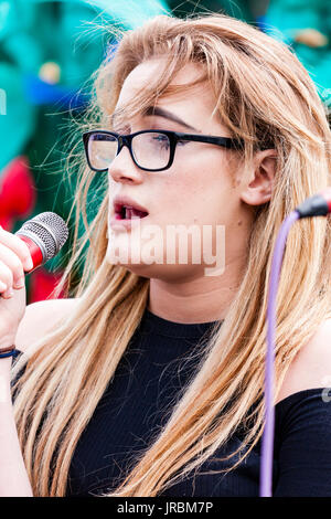 Junge kaukasier blonde Frau mit Brille stehen auf der Bühne singen. Dannli Jayne, Singer Song Writer führt bei eh Ramsgate festival Open Air Bühne. Stockfoto