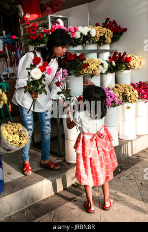 Frau Blume zu geben, ein Zicklein in einem Blumenladen halten einen Blumenstrauß in Kampung Pelangi, Semarang, Java, Indonesien Stockfoto