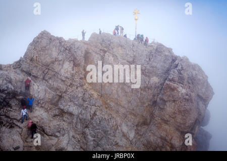 Menschen auf der Zugspitze Gipfel mit Gipfelkreuz, Bayern, Deutschland Stockfoto