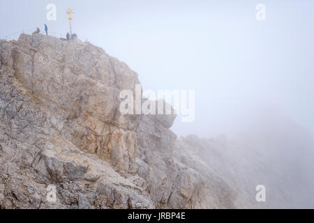 Menschen auf der Zugspitze Gipfel mit Gipfelkreuz, Bayern, Deutschland Stockfoto
