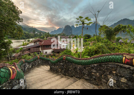 Die traditionellen laotischen Dorf mit Tempel Treppen und Berg Hintergrund in der Nähe von Vang Vieng, Laos. Stockfoto