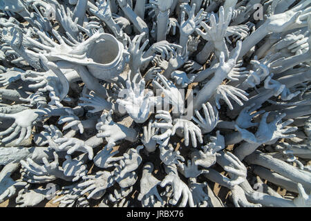 Detail der berühmten Wat Rong Khun (weiße Tempel) in der Provinz Chiang Rai im Norden von Thailand. Hände von der Hölle Stockfoto