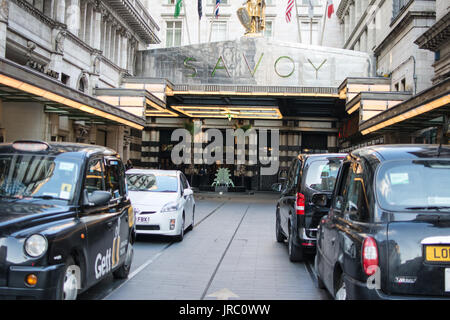 Das Savoy Hotel London Taxi Taxis schwarze Schilder Haupteingang Stadtwagen Auto Touristen Flaggen USA überdachte Gegend Lifestyle Zimmer bleiben berühmt Stockfoto