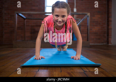 Portrait von Happy teenage Mädchen tun pushup im Fitness Studio. Stockfoto