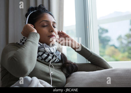 Entspannt Frau Musik von Fenster zu Hause Stockfoto