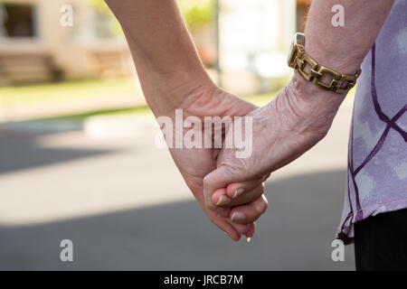 Zugeschnittenes Bild der älteren Frau und Arzt holdings Hände Stockfoto