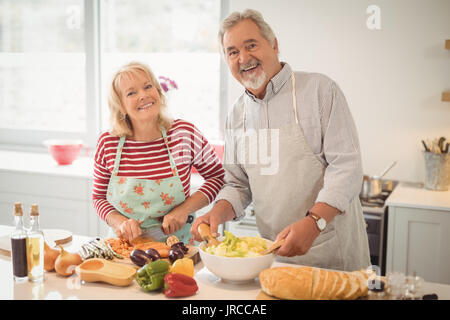 Lächelnd senior Paar Vorbereitung Salat in der Küche zu Hause Stockfoto