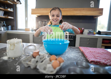 Lächelnde Mädchen Ei im Stehen in der Küche brechen Stockfoto