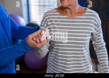 Physiotherapeut die Hand des älteren Patienten in der Klinik Stockfoto