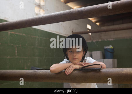 Portrait von cute girl stützte sich auf die Stange in stabilen Stockfoto