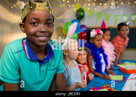 Portrait von junger Mann, Krone mit Freunden im Hintergrund während des Party Stockfoto