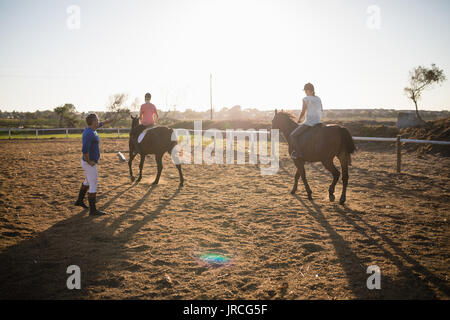 Trainer jungen Frauen in Reiten in der Scheune Stockfoto