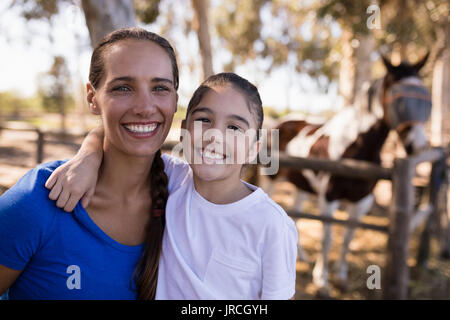 Close up Portrait von lächelnden Schwestern mit Pferd im Hintergrund Stockfoto