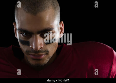 Portrait von bestimmt American football player auf schwarzem Hintergrund Stockfoto