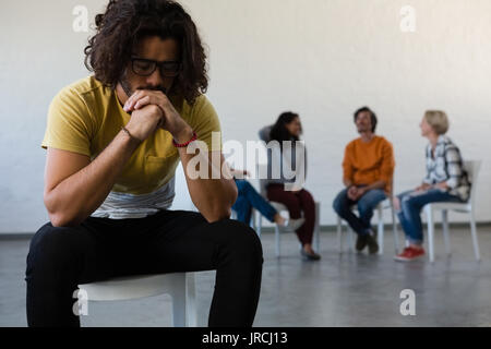 Erwachsene Schüler sitzen auf Stuhl mit Freunden diskutieren im Hintergrund bei Kunst Klasse Stockfoto