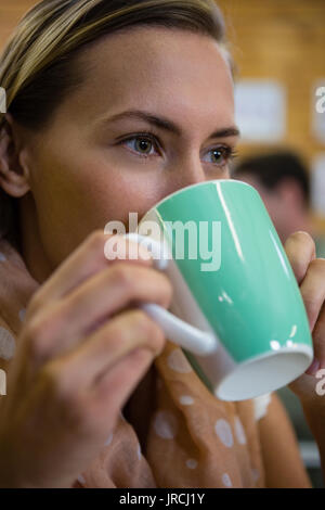 Der nachdenkliche junge Frau trinkt Kaffee im Cafe Stockfoto