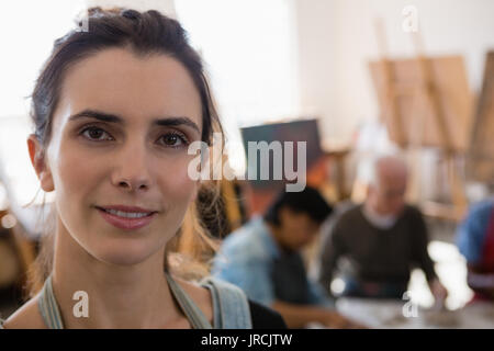 Close up Portrait von lächelnden Lehrer mit älteren Menschen im Hintergrund bei Kunst Klasse Stockfoto