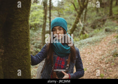 Portrait von Frau mit Vintage Kamera im Wald Stockfoto