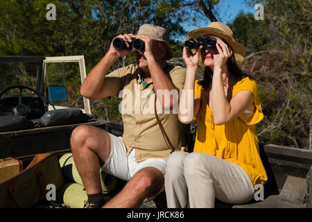 Auf der Suche durch ein Fernglas im Fahrzeug sitzen Stockfoto