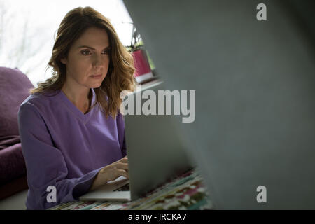 Junge Frau mit Laptop zu Hause Stockfoto