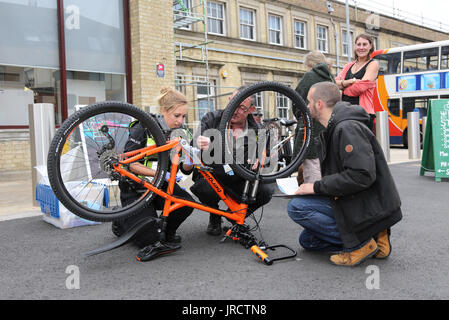 Ein Fahrrad Registrierung Veranstaltung in Cambridge, Großbritannien. Eine Polizistin Sicherheit ist ein Rad, während Details von einem Kollegen aufgezeichnet werden. Stockfoto